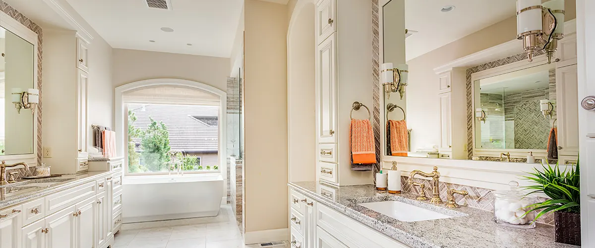 A high-end bathroom remodel cost with golden faucets and granite counter