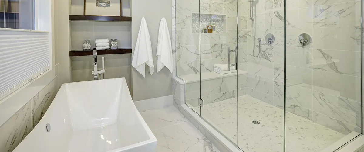 A glass shower and a free standing tub