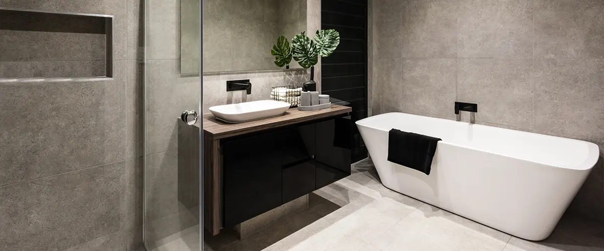 A modern bathroom with large gray tiles on floor and walls