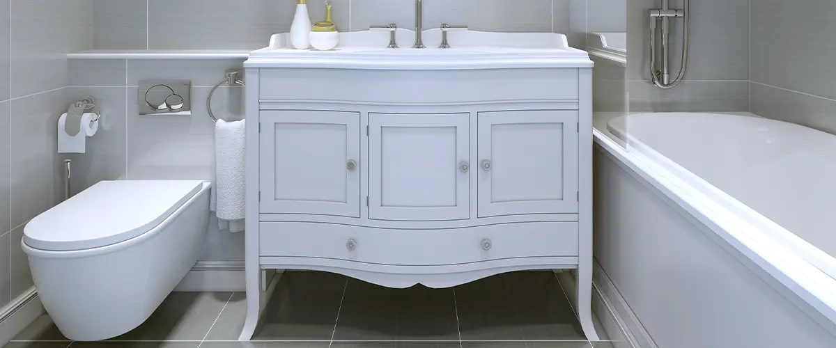 A white vanity with a toilet and a tub in a small bathroom