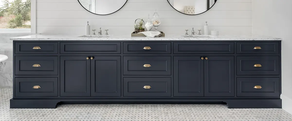 A dark blue double vanity with two round mirrors