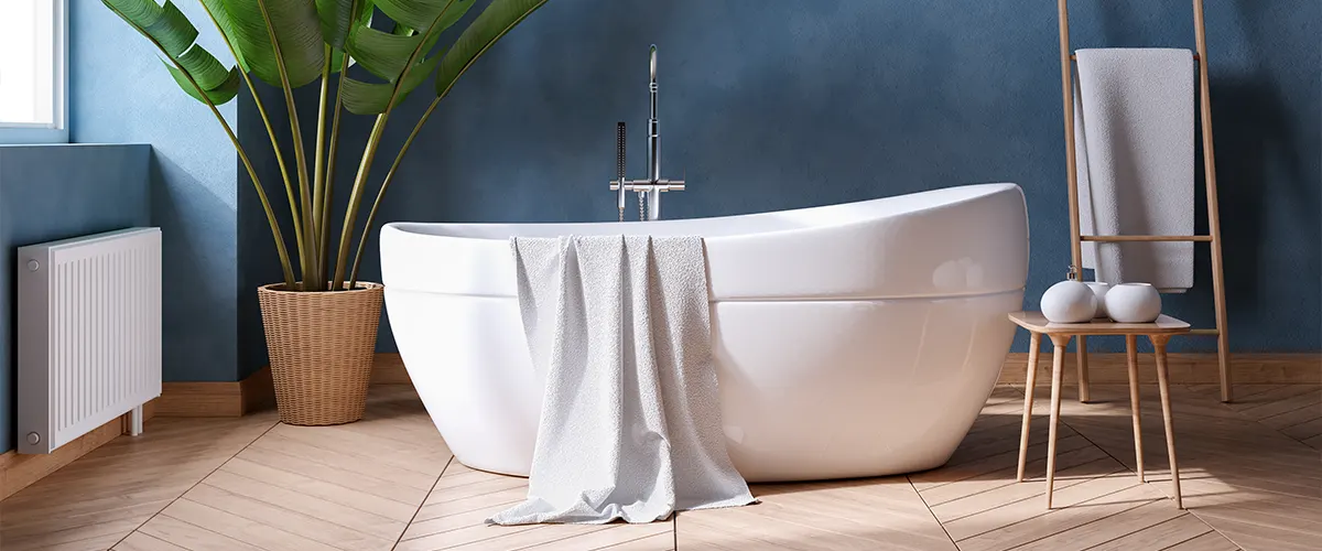 A tub to shower conversion in a bath with a blue wall and a plant