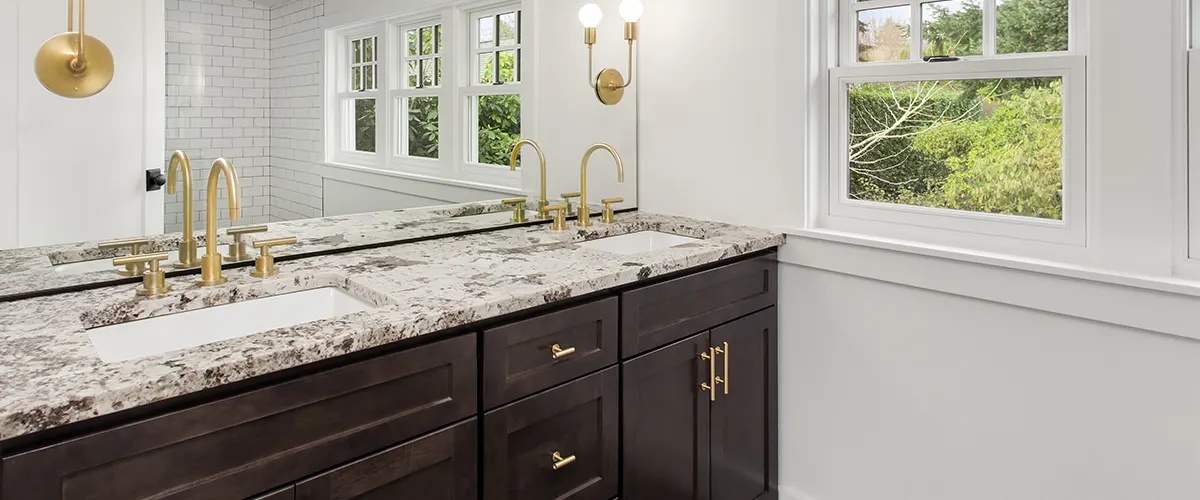 A bathroom counter with golden faucets and golden hardware