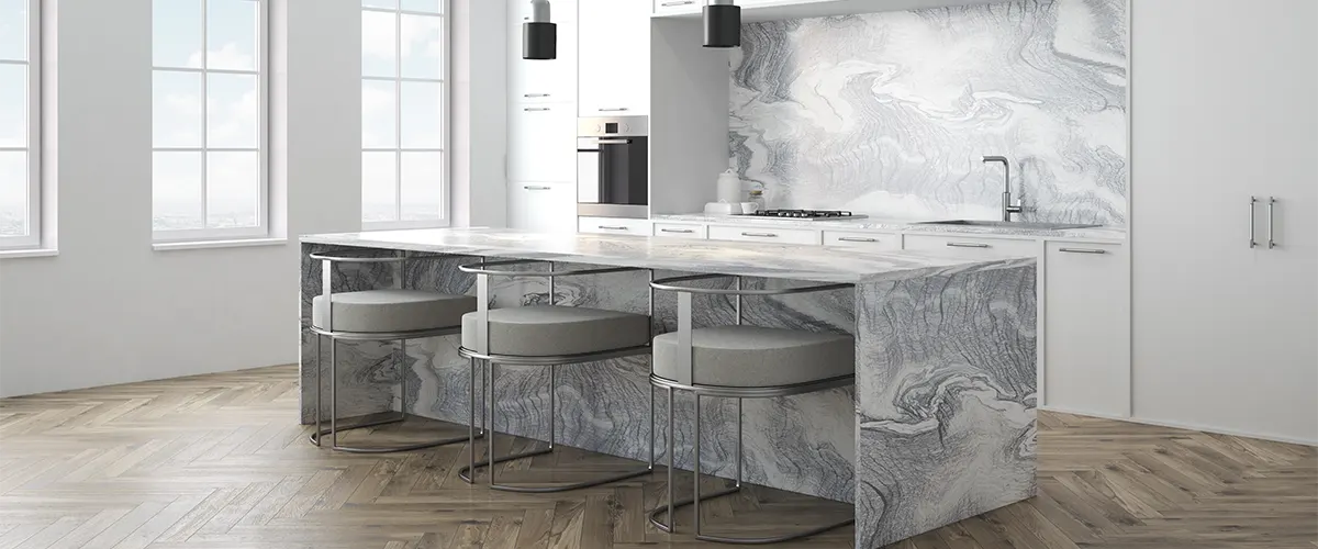 A kitchen island made of marble with gray stools