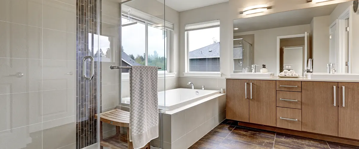 A bathtub resale value and a glass shower in a bathroom with a double wood vanity