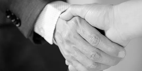 A contractor and homeowner shaking hands on a project