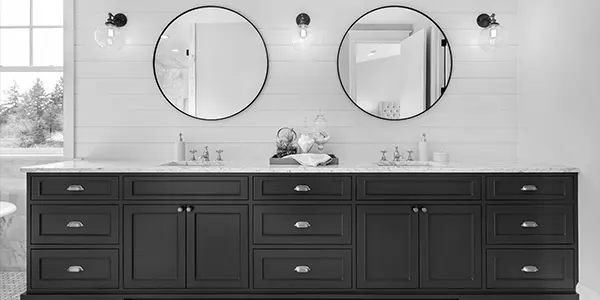 A brand new bathroom with a double vanity and two round mirrors