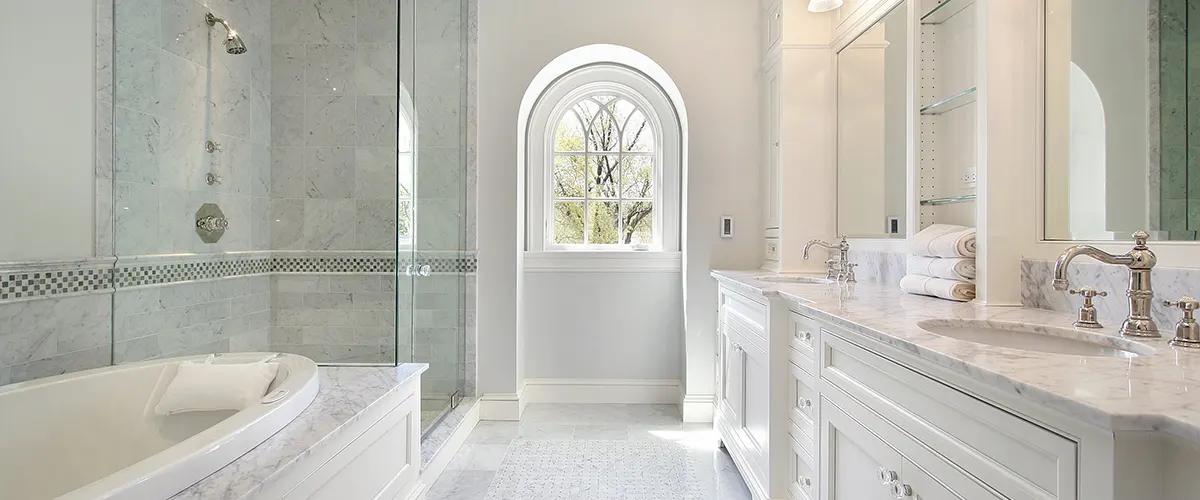 A medium sized bath with a double vanity and glass shower