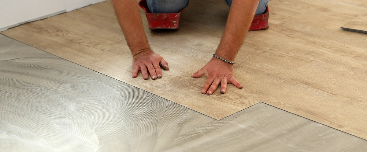 A man installing LVP home flooring