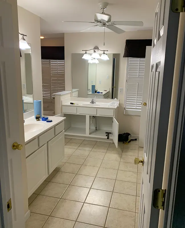 White and cream outdated bathroom with simple tile and old lights