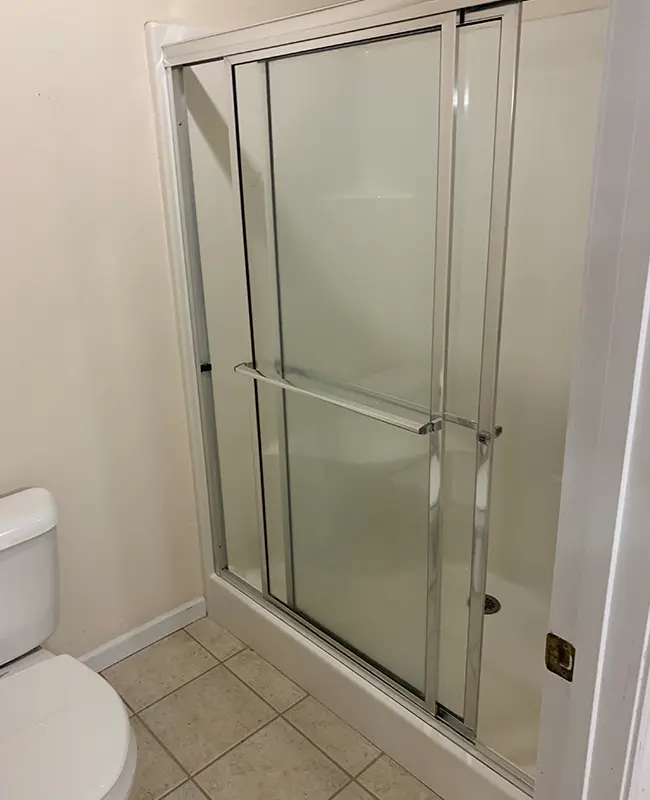 Simple bathroom with simple glass and aluminum shower enclosure
