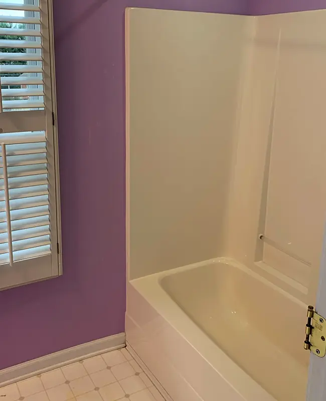 Guest bathroom before tub to shower conversion showing an old white tub with white wall panels