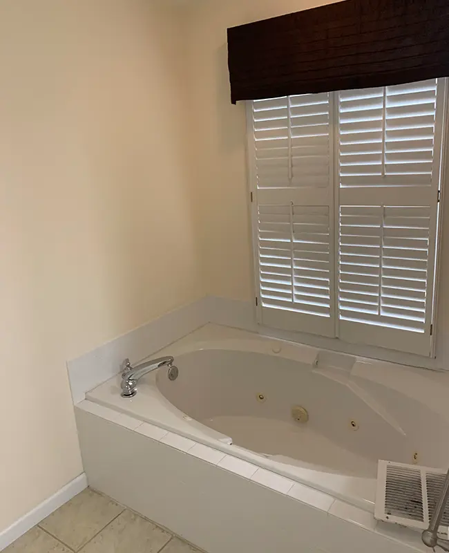 Old bathroom with white jacuzzi tub and cream empty walls