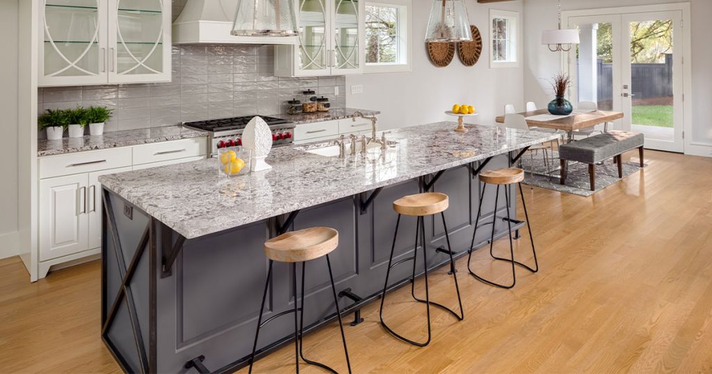 A large granite countertop with wood stools