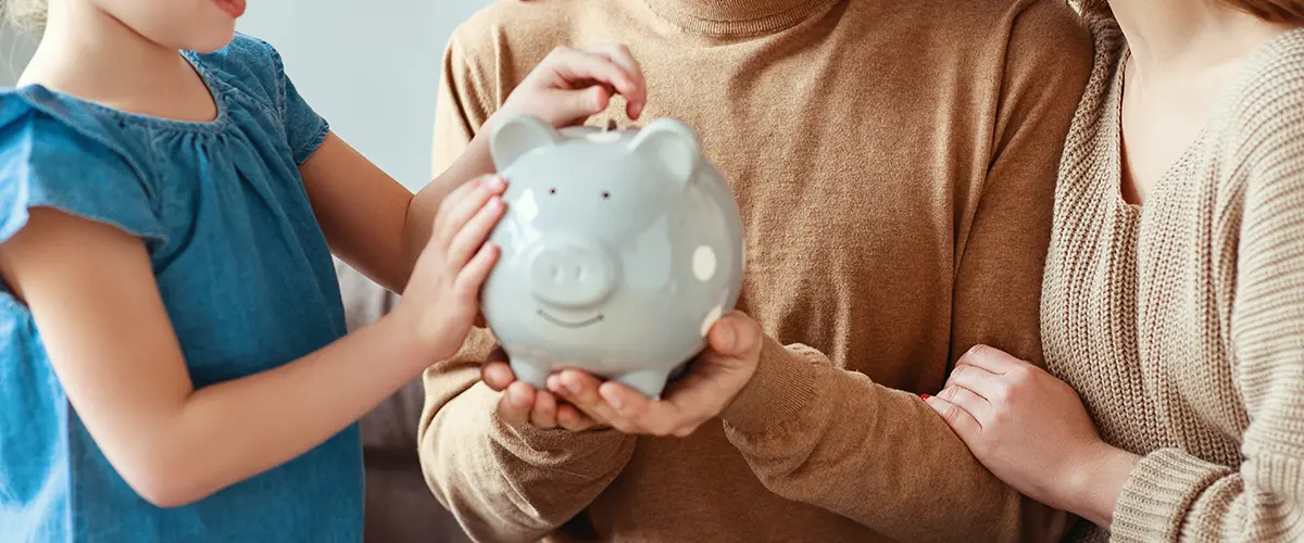 Family with young child holding a piggybank